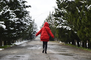 雪后树林小道上的红衣女孩