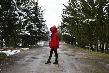 雪后树林小道上的红衣女孩