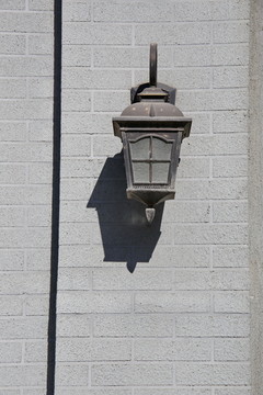 灰墙上老式铁罩路灯
