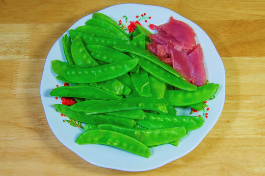 一盘生猪肉片荷兰豆食材