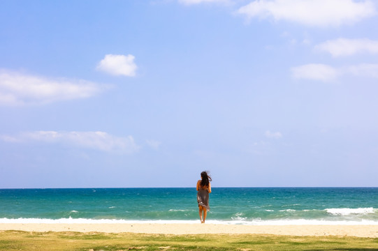 沙滩上面朝大海的女人背影