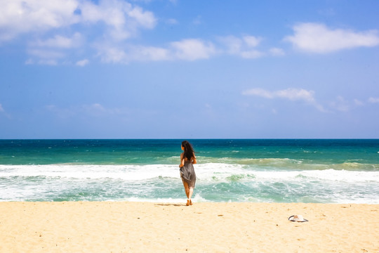 沙滩上面朝大海的女人背影