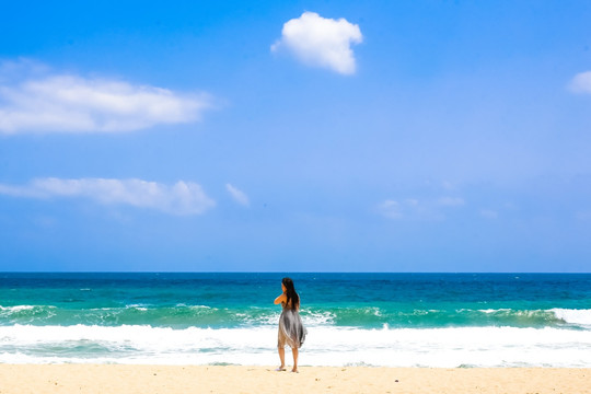 沙滩上面朝大海的女人背影