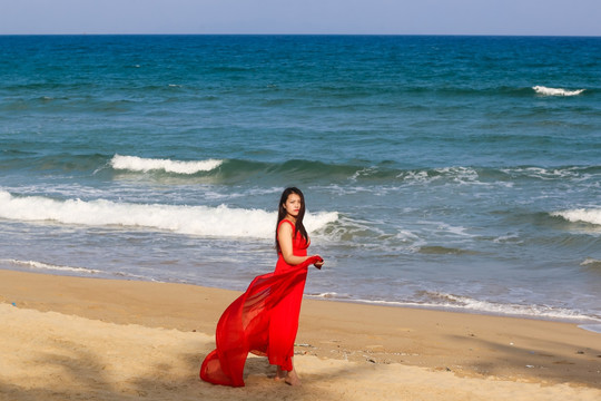沙滩上穿红裙子的女人