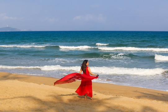 沙滩上穿红裙子的女人