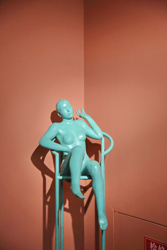 铜雕坐在高脚椅上的丰腴裸体女人