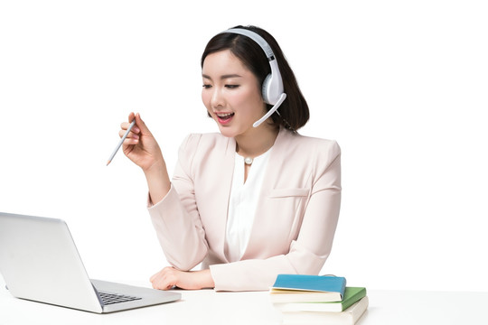 年轻女子戴着耳机使用电脑