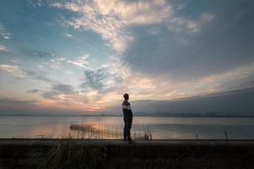 站在海边眺望夕阳的人