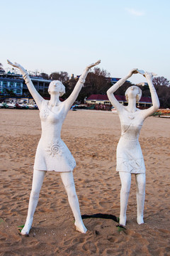 雕塑扬臂仰望天空的两个女人