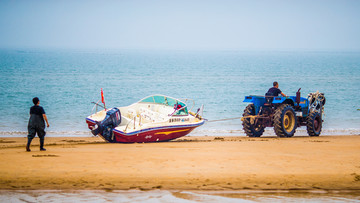 黄金海岸上的拖拉机和游艇