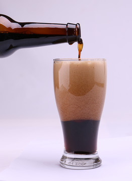 酒瓶倒啤酒黑啤啤酒杯有啤酒泡沫