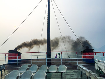 冒着黑烟的海上观光船
