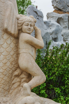 背靠鲤鱼身的女童雕像