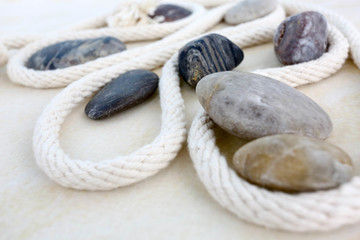 弯曲的纯棉粗绳打结与鹅卵石