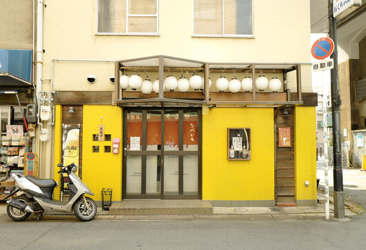 黄色店铺门前的摩托车