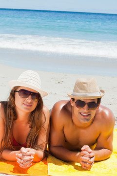 在沙滩上躺在晒日光浴的一对夫妇