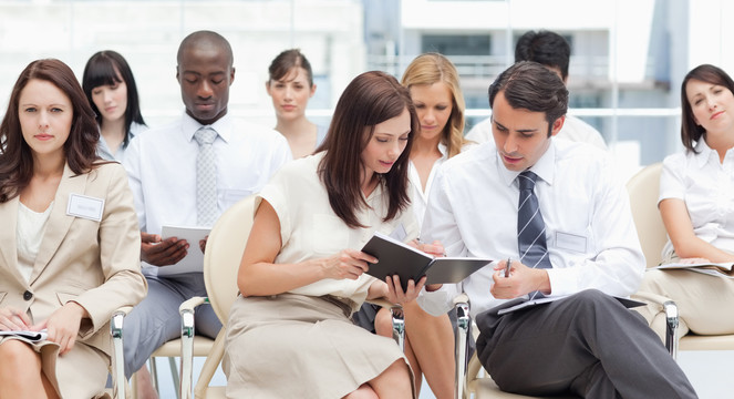 男人和女人坐在一个小组里和同事分享笔记
