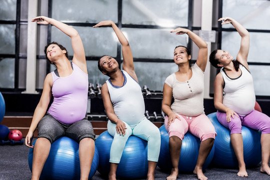 快乐的孕妇健身球上锻炼