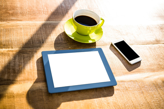桌子上的一杯咖啡和平板电脑