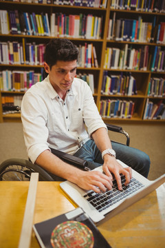 坐轮椅的学生用笔记本电脑打字