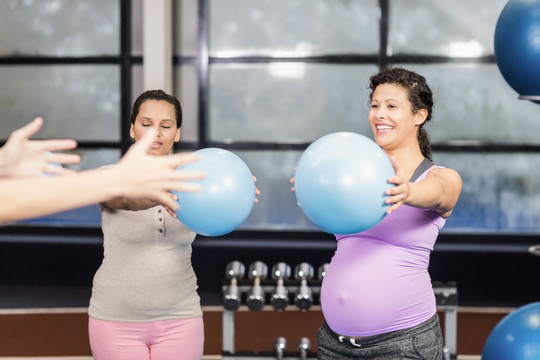 孕妇和教练用健身球锻炼