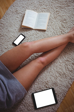 在家里用书本和技术俯视女性的腿