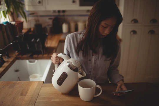 黑发女人把水倒在杯子里