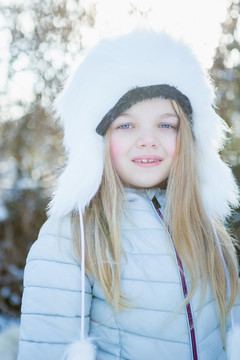 雪天穿冬衣的可爱女孩的肖像