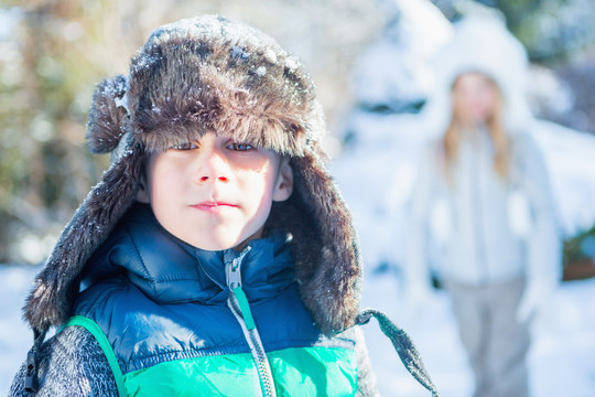 雪天穿冬衣的可爱男孩的肖像