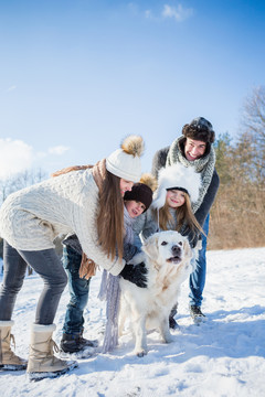 一家人在雪天和狗玩耍