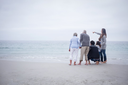 一家人站在一起看着大海