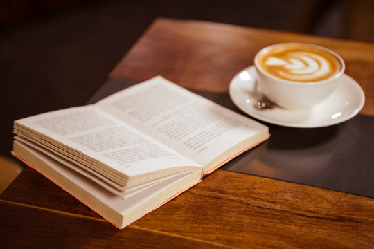 一杯卡布奇诺加咖啡艺术和书籍