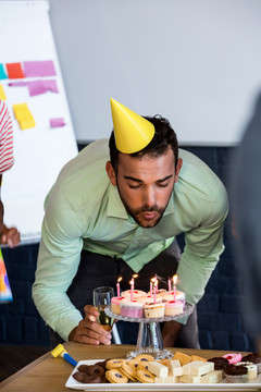 在生日蛋糕上吹蜡烛的人