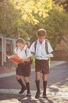 学校的孩子在校园里边走边看书