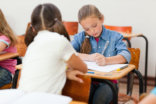 小学生在课堂上帮助同学