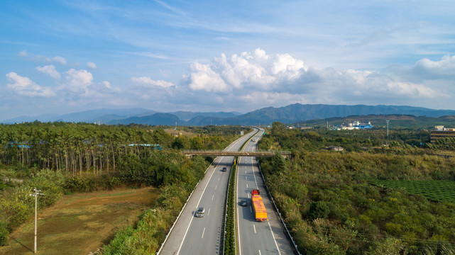 晴朗天空下田野中穿行的高速公路