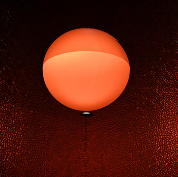 橙色圆形吊灯及深红色毛玻璃背景