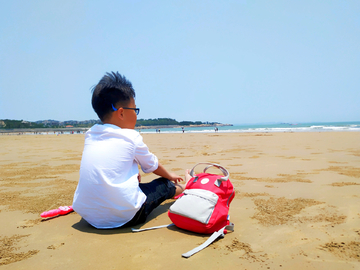 坐在海滩上的小男孩