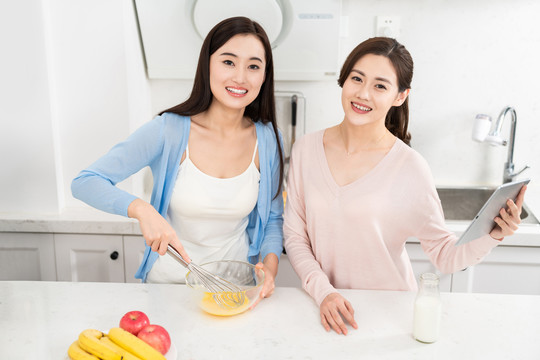 年轻女子在厨房边做饭边和朋友聊天