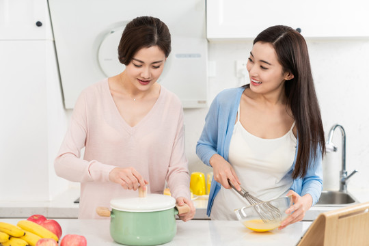 年轻女子在厨房边做饭边和朋友聊天