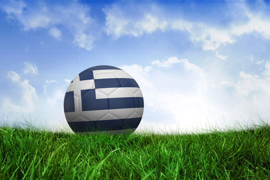 希腊足球在蓝天下的草地上