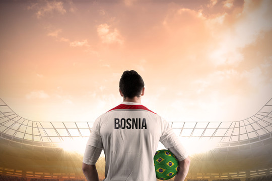 波斯尼亚运动员拿着球面对足球场