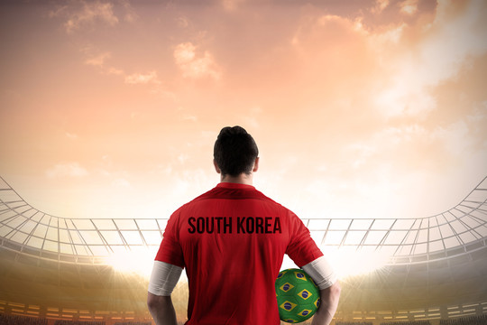 韩国足球运动员拿着球面对足球场