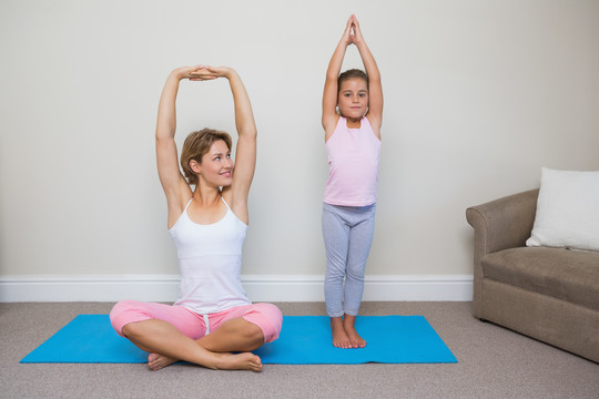 妈妈和女儿在客厅里做瑜伽