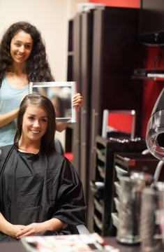 一位理发师向顾客展示新发型