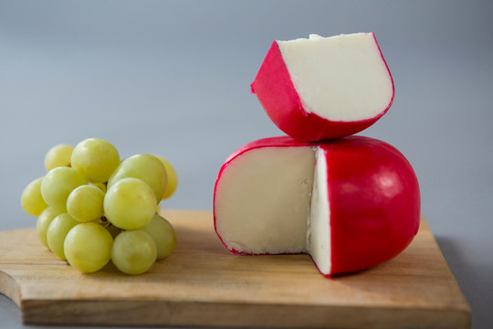 切碎板上的奶酪和葡萄