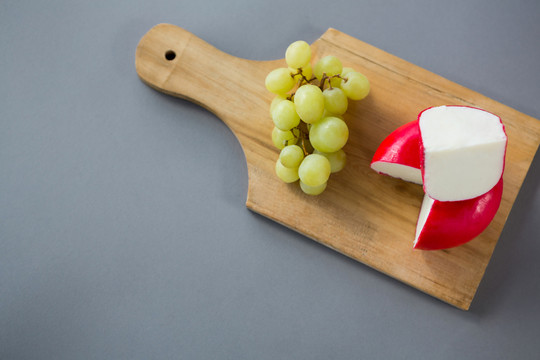 切碎板上的奶酪和葡萄
