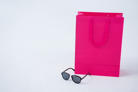 粉色购物袋和眼镜