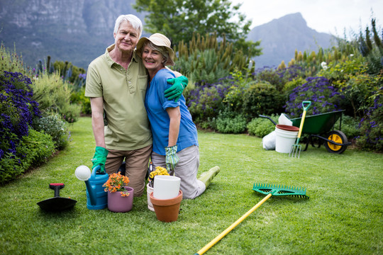 在草坪上种花的老年夫妇