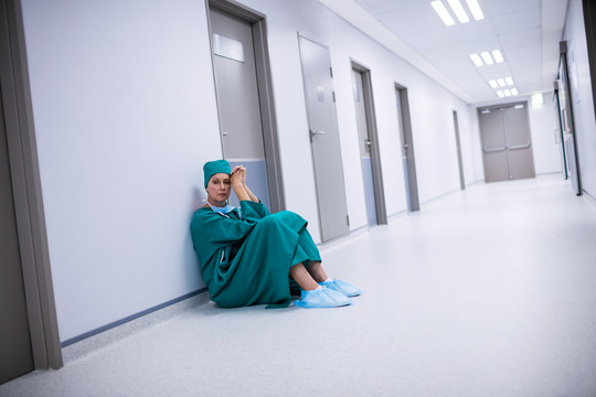 紧张的女外科医生站在走廊